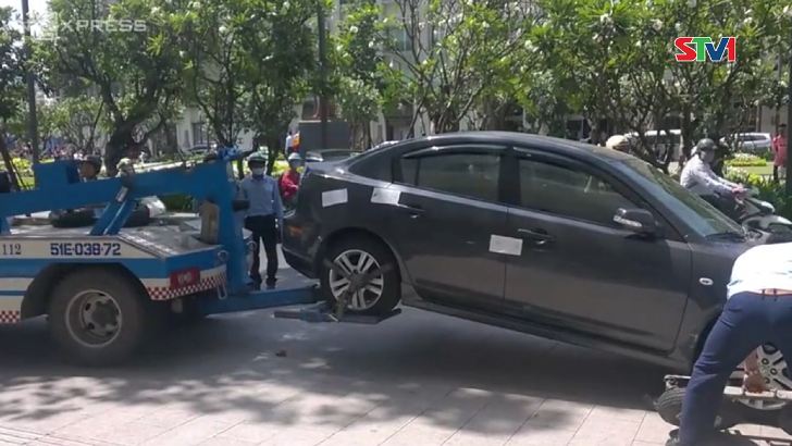 Hàng loạt ôtô biển xanh đậu trên vỉa hè TP HCM bị xử phạt